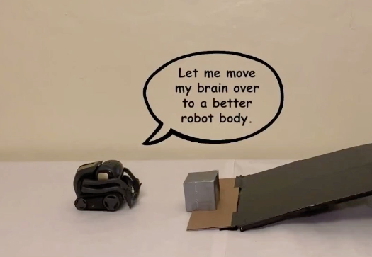 A black robot with a speech bubble saying "Let me move my brain over to a better robot body". The scene also has a box and a ramp.